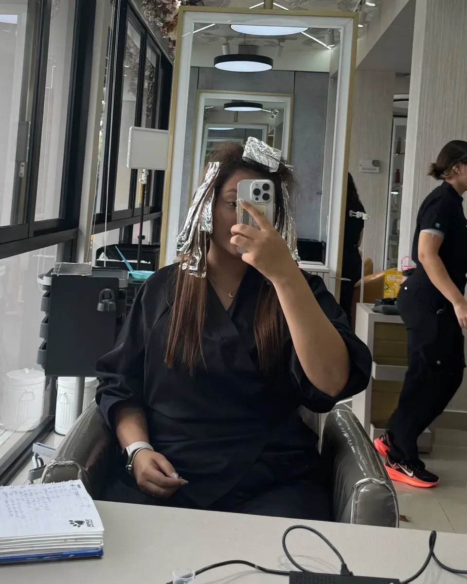 Antes: clienta con papel aluminio durante el balayage, en el salón.